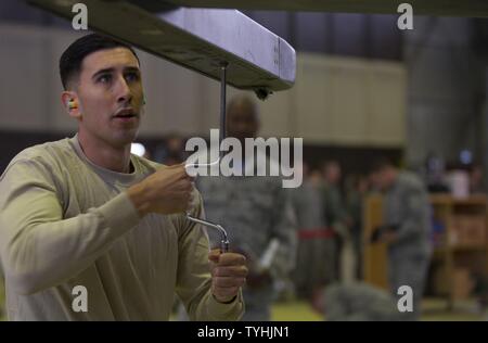 Us Air Force Staff Sgt. Matthäus Alcala, 52 Aircraft Maintenance Squadron Waffen-Spezialisten und Last crew Competition Team Mitglied, arbeitet an einer F-16 Fighting Falcon während der vierteljährlichen Waffen laden Wettbewerb im Hangar 1 in Spangdahlem Air Base, Germany, November 10, 2016. Die Last crew Wettbewerb erforderlich zwei Teams von drei konkurrierenden Mitglieder Waffen auf den Flügeln einer F-16 zu laden so schnell und genau wie möglich. Stockfoto
