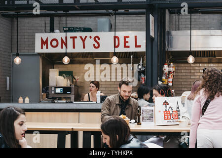 London, UK, 15. Juni 2019: Personen, die vor der Montys NYC style deli stand auf Spitalfields Market, eine der schönsten Hallen in London w Stockfoto