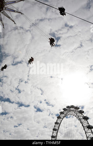 Passagiere auf einer Schaukel oder Stuhl Swing Fahrt mit dem London Eye im Hintergrund, London Stockfoto