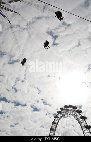 Passagiere auf einer Schaukel oder Stuhl Swing Fahrt mit dem London Eye im Hintergrund, London Stockfoto