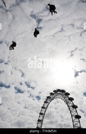 Passagiere auf einer Schaukel oder Stuhl Swing Fahrt mit dem London Eye im Hintergrund, London Stockfoto