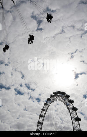 Passagiere auf einer Schaukel oder Stuhl Swing Fahrt mit dem London Eye im Hintergrund, London Stockfoto