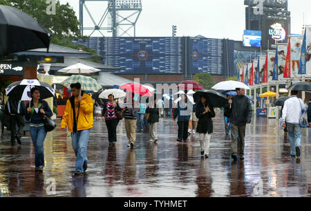 Menschen kommen für die night Session Übereinstimmungen als die Lichter der Arthur Ashe Stadium reflektiert die nasser Fahrbahn während der Regen wieder schiebt spielen bei den US Open am USTA Billie Jean King National Tennis Center am 5. September, 2006 in New York. (UPI Foto/Monika Graff) Stockfoto