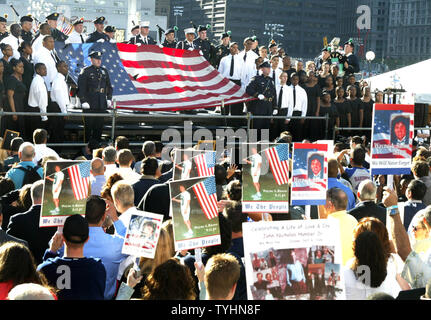 Eine Flagge in den Trümmern der eingestürzten Zwillingstürme gefunden wird gehalten, wenn die Nationalhymne gesungen wird, während die Familienangehörigen der Opfer des 11. September 2001 Terroranschläge die Zeremonie zum Gedenken an den fünften Jahrestag am Ground Zero am 11. September 2006 in New York teilnehmen. (UPI Foto/Monika Graff) Stockfoto