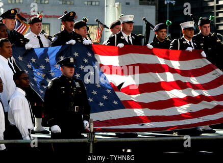 Eine Flagge in den Trümmern des eingestürzten World Trade Center gefunden wird gehalten, wenn die Nationalhymne als Familienmitglieder der Opfer des 11. September gesungen, 2001 Terroranschläge die Zeremonie zum Gedenken an den fünften Jahrestag am Ground Zero September 11, 2006 in New York teilnehmen. (UPI Foto/Monika Graff) Stockfoto