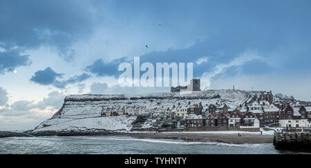 Hafen und schneebedeckten East Cliff mit St Mary's Church, Whitby, North Yorkshire, UK. Stockfoto