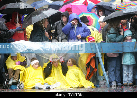 Zuschauer tun, was Sie in den gusty Regen und Temperaturen von 40 Grad, wie Sie sehen Sie sich das 80Th Thanksgiving Day Parade von Macy's anzusehen am 23. November 2006 in New York City trocken zu halten. Jedes Jahr tausende Zeile die 2 1/2 Meile parade Route der Prozession von Schwimmern, Marching Bands und Stars zu sehen. (UPI Foto/Monika Graff) Stockfoto