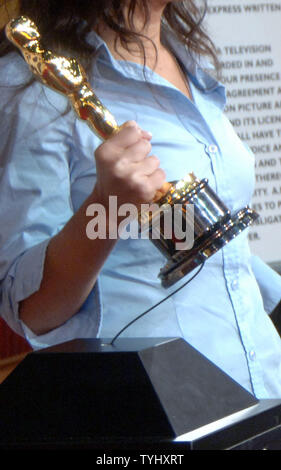 Ein Tourist hält einen Oscar statue beim Besuch der "Meet the Oscars' Tour, die zeigen, 50 Oscar Statuetten in New York vom 12. bis 24. Februar 2007 bis zum 25. Februar 2007 auf dem 79. jährlichen Academy Awards in Los Angeles vorgestellt. Ein flaches Kabel an der Unterseite des Oscar statue befestigt ist installiert, um Diebstahl zu verhindern. (UPI Foto/Ezio Petersen) Stockfoto