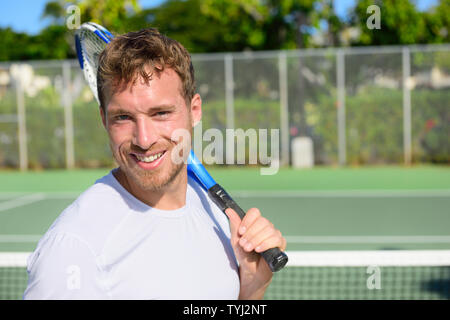 Portrait der männlichen Tennisspieler holding Tennisschläger nach Spielen im Spiel auf Hard Court im Sommer. Passen mann Sport Fitness Athlet Lächeln glücklich leben gesunden, aktiven Lebensstil außerhalb. Stockfoto
