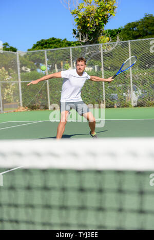 Tennis Player - Mann schlagen Vorhand draußen spielen auf Hartplatz. Männliche Sport Fitness Sportler üben im Sommer im Freien, gesunden, aktiven Lebensstil. Stockfoto