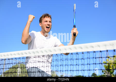 Tennis Spieler feiern den Sieg. Gewinnen jubelnde Menschen in der Feier der Erfolg glücklich und gewinnen. Passen männlichen Athleten Sieger auf Tennisplatz im Freien holding Tennisschläger im Triumph durch das Netz. Stockfoto