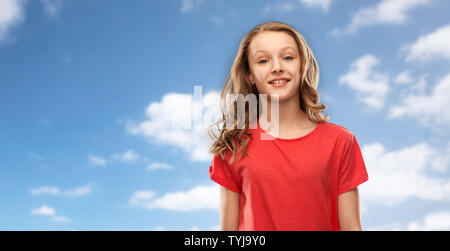 Smiling teenage Mädchen im roten T-Shirt über das Sky Stockfoto
