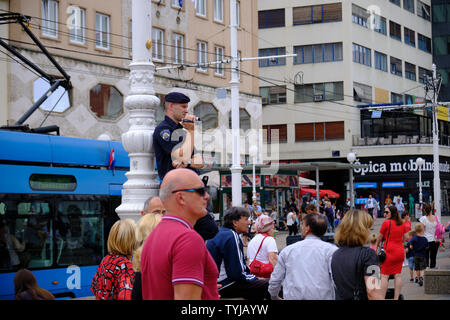 Zagreb, Kroatien, 23. Juni 2019: Polizist thront Dreharbeiten Rechtsgerichtete politische Kundgebung in Stadt Hauptplatz Stockfoto