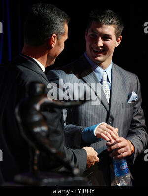 Universität von Florida Quarterback, Tim Tebow, lächelt Florida Fußball Trainer städtischer Meyer (L) im Hard Rock Cafe in New York City am 8. Dezember 2007. Tim Tebow wird der erste sophomore Die Heisman Trophy, die je in 73 Jahren zu gewinnen. (UPI Foto/John angelillo) Stockfoto