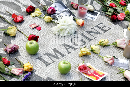 Blumen und andere Gegenstände auf dem "Imagine" Mosaik als Fans von ex-Beatle Sänger und Songwriter John Lennon sammeln Hommage an ihn bei Strawberry Fields in Central Park pay am 27. Jahrestag seines Todes am 8. Dezember 2007 in New York. Lennon wurde von deranged Ventilator Mark David Chapman vor dem Dakota Building, wo Lennon über der Straße vom Park lebte erschossen. (UPI Foto/Monika Graff). Stockfoto