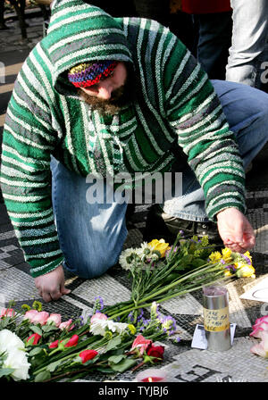 Ein Fan von ex-Beatle Sänger und Songwriter John Lennon, der eine Stick von Weihrauch als Menschen bei Strawberry Fields in Central Park Sammeln der 27. Jahrestag der Lennons Tod am 8. Dezember 2007 in New York zu beobachten. Lennon wurde von deranged Ventilator Mark David Chapman vor dem Dakota Building, wo Lennon über der Straße vom Park lebte erschossen. (UPI Foto/Monika Graff) Stockfoto