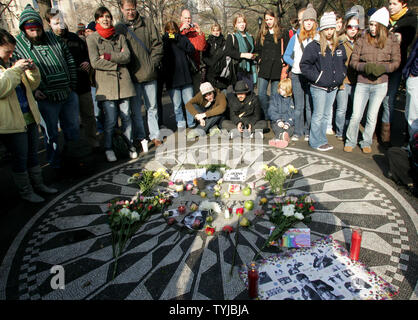 Fans von ex-Beatle Sänger und Songwriter John Lennon zollen ihm bei Strawberry Fields in Central Park auf der 27. Jahrestag seines Todes am 8. Dezember 2007 in New York. Lennon wurde von deranged Ventilator Mark David Chapman vor dem Dakota Building, wo Lennon über der Straße vom Park lebte erschossen. (UPI Foto/Monika Graff) Stockfoto