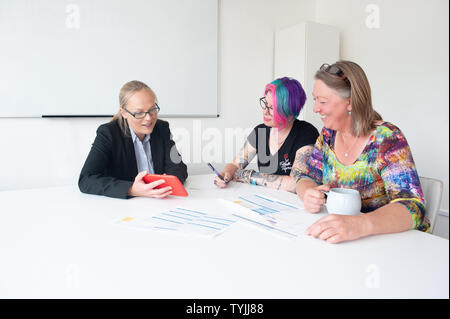 Drei Frauen in der informellen Wirtschaft Einstellung in Diskussion mit Schreibarbeit Stockfoto
