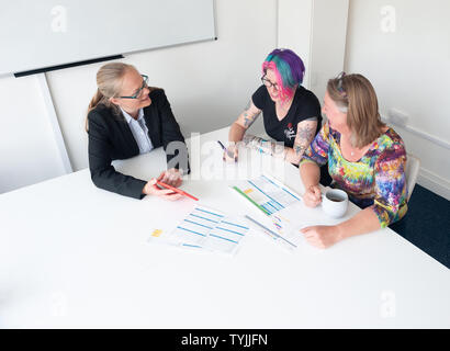 Drei Frauen in der informellen Wirtschaft Einstellung in Diskussion mit Schreibarbeit Stockfoto