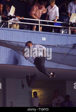 Ein Ventilator erreichen für ein Foul Ball fällt in das Netz hinter der Home Plate im siebten Inning der New York Yankees, Baltimore Orioles Spiel im Yankee Stadium in New York City am 29. Juli 2008. (UPI Foto/John angelillo) Stockfoto