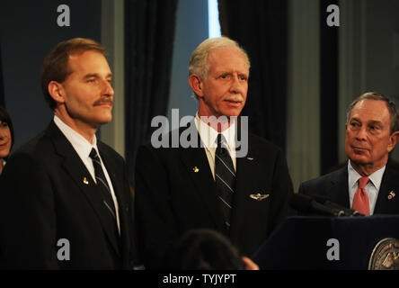 New York City Bürgermeister Michael Bloomberg (R) schaut auf, während Captain Chesley Sullenberger von Ully' (C) und First Officer Jeffery Skiles beantworten Fragen nach der Besatzung der Schlüssel zum New York City für Pilot Sullenberger erfolgreiche Crash von US Airways Flug 1549, eingegangen am 15. Januar 2009 in den Hudson River mit Keine verlorenen Leben bei der City Hall Zeremonien in New York am 9. Februar 2009. (UPI Foto/Ezio Petersen) Stockfoto