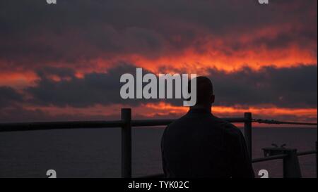 Pazifik (Nov. 12, 2016) ein Matrose Uhren die Sonne im Pazifik auf dem Flugzeugträger USS Carl Vinson (CVN 70) Fantail eingestellt. Carl Vinson wird derzeit die Durchführung von Composite Trainingsgerät Übung (COMPTUEX) in Vorbereitung für eine bevorstehende Bereitstellung. Stockfoto