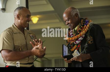 Us Marine Brig. Gen. Brian W. Cavanaugh, stellvertretender Kommandeur des US Marine Corps Forces, Pazifik, präsentiert der Congressional Gold Medal Dr. Ernest James Harris, Jr. während einer Zeremonie in Honolulu, Nov. 12, 2016. Harris war seine Congressional Gold Medal für seinen Dienst als Montford Point Marine ausgezeichnet. Stockfoto