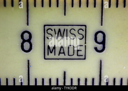 Makro Nahaufnahme des Swiss made Dichtung auf vintage Kunststoff gelb Zollstock gedruckt Stockfoto