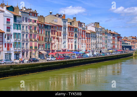 Blick auf typische baskische Architektur auf Häusern entlang des Flusses Nive. Seitenansicht von der Brücke. Bayonne, Frankreich Stockfoto