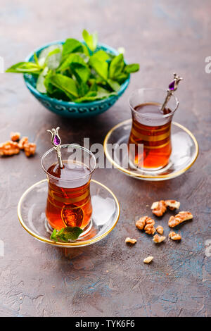 Traditionelle türkische arabische Dessert und einem Glas Tee mit Minze und Muttern Stockfoto