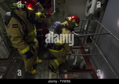 Karibik (Nov. 14, 2016) Segler auf USS Zumwalt (DDG 1000) bewegen Sie sich durch die wichtigsten Maschinen Zimmer ein, um den Standort eines Feuer während eines General Quarters Übung zugewiesen. Mit Crew von 147 Segler, Zumwalt ist das Typschiff einer Klasse von Zerstörern der nächsten Generation konzipiert Seemacht, indem Sie kritische Missionen und die Verbesserung der US-Abschreckung, die Projektion und das Meer steuern Ziele zu stärken. Stockfoto