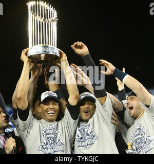 Mariano Rivera (L), Hebezeuge die WM-Trophäe als Melky Cabrera, Mitte, und Nick Swisher der New York Yankees, dem World Series feiern Sieg nach dem Sieg über die Philadelphia Phillies in Spiel sechs im Yankee Stadium am 4. November 2009 in New York City. UPI Foto/Monika Graff. Stockfoto