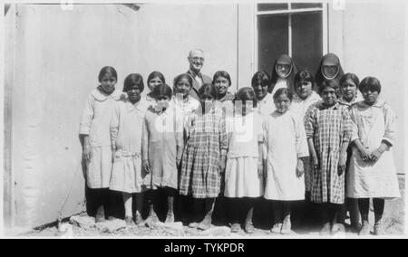 Schüler und Lehrer der Pueblo tag Schule.; Umfang und Inhalt: Das ist ein Foto von der McCarty's, Acomita, oder Santo Domingo Tag Schulen, von den Vereinigten Pueblos Agentur in New Jersey verwaltet. Die Agentur wurde 1935 in Albuquerque, durch Konsolidierung der Santa Fe und Albuquerque indischen Schulen, die Zuni Indian Agentur, die Albuquerque Sanatorium, südlichen und nördlichen Pueblos Agenturen, und die Navajo Gemeinschaften unter Canoncito und Alamo. Der Tag, an dem dieses Foto aufgenommen wurde war früher unter der Jurisdiktion des Südlichen Pueblos Agentur. Stockfoto