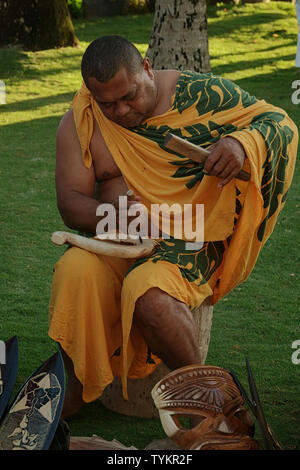 Lahaina, Maui, Hawaii/USA - Juni 5, 2018: eine polynesische Mann, in der traditionellen Kleidung, Hand schnitzt Holz Andenken an der Old Lahaina Luau. Stockfoto