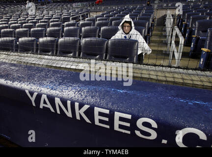 Ein Lüfter sitzt im Regen in der zweiten Reihe hinter der Home Plate, bevor die Baltimore Orioles Spiel der New York Yankees im Yankee Stadium in New York City am 12. April 2011. Das Spiel wurde verschoben und verschoben. UPI/John angelillo Stockfoto