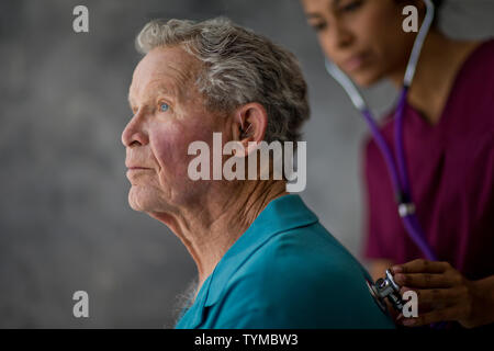 Krankenschwester hören Herzschlag eines älteren Patienten. Stockfoto