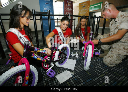 Marine Charles Blake von Wichita, Kansas, hilft dabei, Miss USA Kandidaten Bretagne Weiser (L) des Montanta, Erza Haliti von Idaho, Mitte, und Jillian Wunderlich von Indiana während der USO bauen Sie ein Bike Event, wo Fahrräder sind zusammenbauen und an der militärischen Familien am Pier 88 Am 26. Mai gestiftet, 2011 in New York City. UPI/Monika Graff. Stockfoto