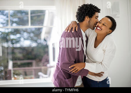 Glückliches junges Paar umarmen in ihrer neuen Heimat. Stockfoto