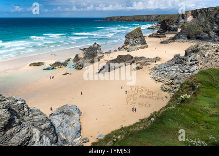 Eine Warnung in den Sand geschrieben am Strand an der robusten, spektakuläre Bedruthan Steps auf der nördlichen Küste von Cornwall. Stockfoto