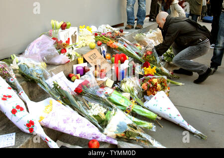 Ein Mann legt Blumen an einem shift Schrein zu Ehren von Apple Mitbegründer Steve Jobs vor dem Apple Store in der Fifth Avenue haben am 6. Oktober 2011 in New York City. Jobs vergeht der Tag nach dem Kampf gegen Bauchspeicheldrüsenkrebs. UPI/Monika Graff Stockfoto