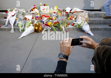 Ein Mann mit einem iPhone zu fotografieren einen shift Schrein, ehrt die Apple Mitbegründer Steve Jobs vor dem Apple Store in der Fifth Avenue haben am 6. Oktober 2011 in New York City. Jobs vergeht der Tag nach dem Kampf gegen Bauchspeicheldrüsenkrebs. UPI/Monika Graff Stockfoto