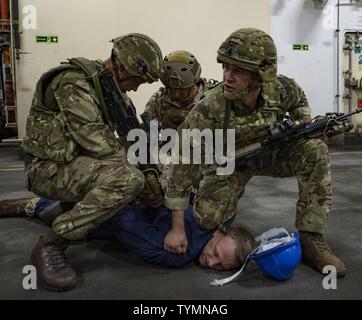 Service Mitglieder zugeordnet Commander Task Group 56.1 (CTG 56,1), die Beseitigung von Explosivstoffen Mobile Einheit (EODMU) 1 und die 45 Commando Royal Marines an bord RFA Lyme Bay (L 3007), exchange Close Quarters begonnen Kampf Techniken während Großbritannien - USA Meine Gegenmaßnahmen Übung 17-1. Die Übung dient der bilateralen Zusammenarbeit, gegenseitige MCM Fähigkeiten und die Interoperabilität zwischen den USA und Großbritannien Seestreitkräfte in den freien Fluss des Handels, die Freiheit der Schifffahrt und langfristige regionale Sicherheit zu erhöhen. EODMU-1 ist derzeit zur Unterstützung der CTG 56.1 bereitgestellt. CTG -56,1 führt meine counterm Stockfoto