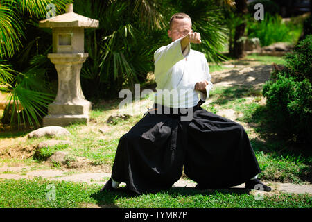 Junge ernster Mann aikido Master in traditioneller Tracht Stockfoto