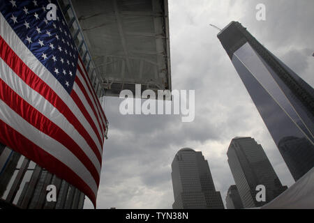 Das One World Trade Center steht auf der rechten Seite einer Flagge, die auf 4 World Trade Center zu einem Richtfest hängt vor der endgültigen Stahl Strahl wird mit einem Kran an die Spitze der Vier World Trade Center in New York City am 25. Juni 2012 erhoben. UPI/John angelillo Stockfoto