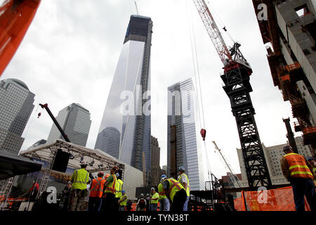 Das One World Trade Center steht über Bauarbeiter bei einem Richtfest vor der endgültigen Stahl Strahl wird mit einem Kran an die Spitze der Vier World Trade Center in New York City am 25. Juni 2012 erhoben. UPI/John angelillo Stockfoto