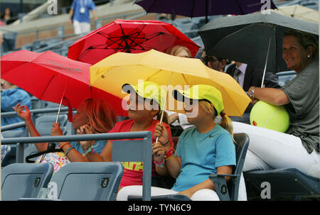 Ventilatoren nehmen Abdeckung unter Sonnenschirmen wie der Regen beginnt zu fallen während der Samantha Stosur, Australien, gegen Victoria Azarenka, Belarus, Gleiches bei den US Open 2012 am National Tennis Center am 4. September 2012 statt. UPI Foto/Monika Graff Stockfoto