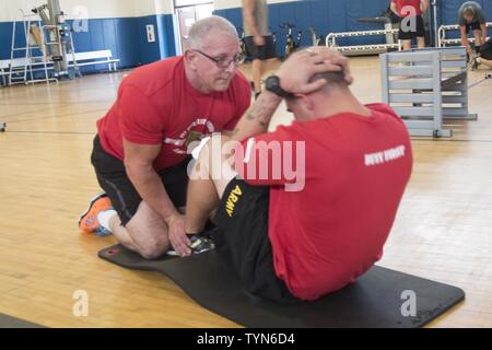 Robert Irvine, Starkoch, hält die Füße von einem "Big Red One" Soldat während der Sit-up Teil der Physischen Ausbildung bei Craig Fitness Center in Fort Riley, November 17. Irvine ist eine Fitnessbegeisterte und hat körperliches Training mit mehreren Niederlassungen des Militärs während seiner Besuche zu den Truppen. (Sgt. Michael C. Roach, 19 Public Affairs Abteilung) Stockfoto