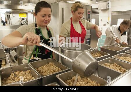 Verschlingen sie verschlingen! Happy Thanksgiving! Freiwillige aus der 104 Fighter Wing ein Thanksgiving Festmahl mit Hilfe der Gemeinschaft Partner für die lokalen Jungen und Mädchen Verein im westlichen Massachusetts vorbereiten! Tech Sgt. Lauren Gallagher und Senior Airman Kayla Gallagher von der 104 Fighter Wing, bereiten Füllung für die jährliche Tradition. Stockfoto