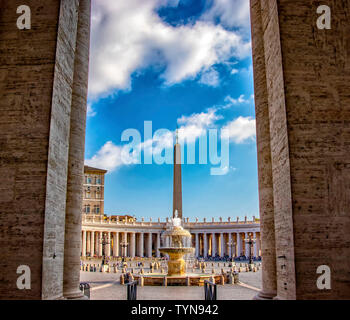 Blick auf den Brunnen und der Säule auf dem Platz im Vatikan, Italien. Es gibt einen wunderschönen blauen Himmel mit Wolken im Hintergrund. Stockfoto