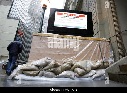 Ein Mann von einer U-Bahn Schließung von Kunststoff- und Sandsäcke in der Nähe von Wall Street umgeben, wie Hurrikan Sandy Ansätze in New York City am 29. Oktober 2012. Die schlimmsten Sturm in New York wird voraussichtlich zwischen 3 Uhr und 3 Uhr Montag Dienstag auftreten, je nach den nationalen Wetterdienst. UPI/John angelillo Stockfoto